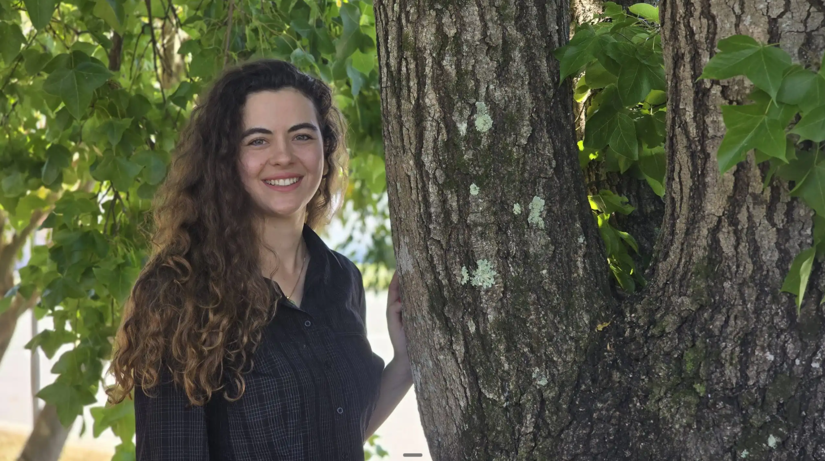 Charlotte Bryan, founder of Warp App Development, standing by a tree